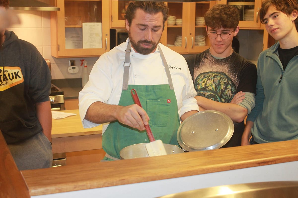 Chef Curtis demonstrating a broccoli cheddar soup to seniors Nathaniel Cote and Jonathan Coulton.
