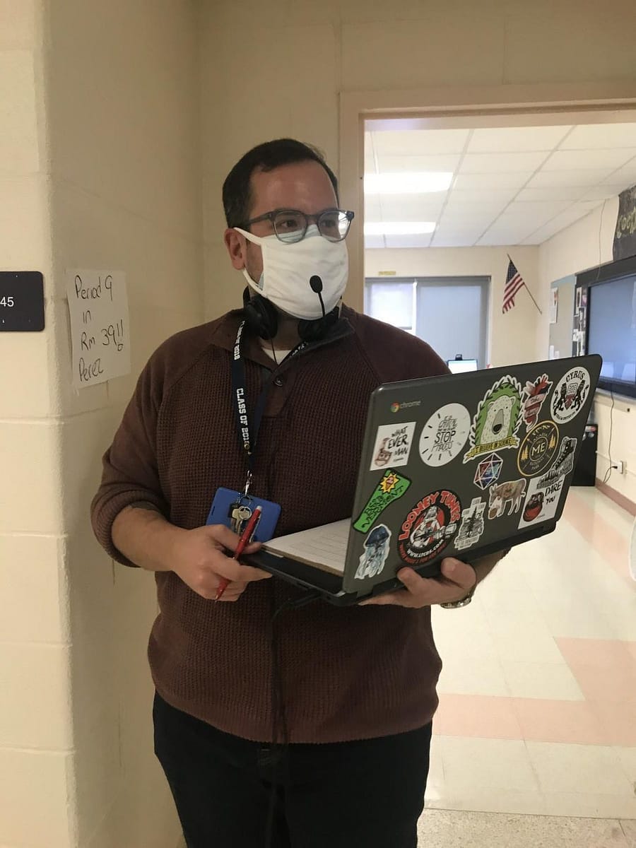 Mr. Perez prepares for teaching his global class virtually and in-person simultaneously.